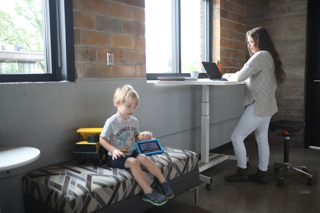 Two colleagues collaborating over a laptop in a bright office