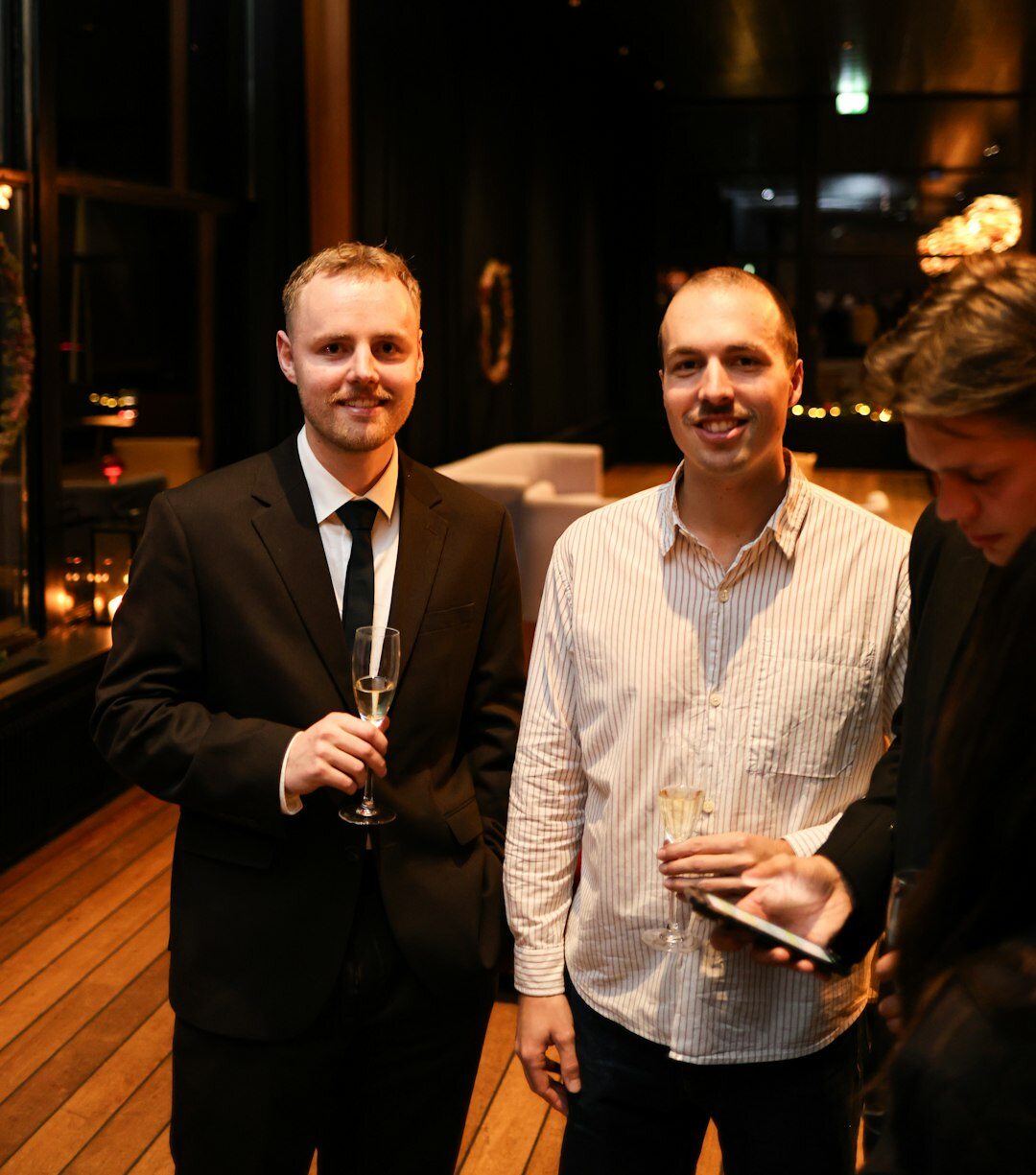 Professionals networking with drinks at an evening business event